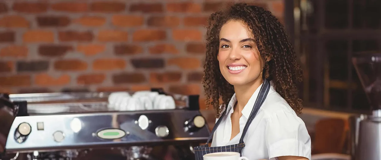 Female African American barista in front of coffee machine